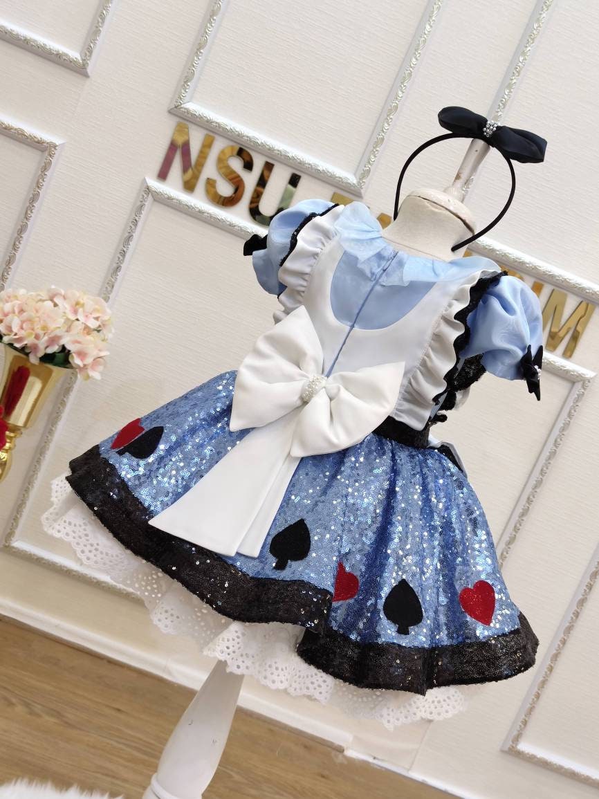 Sparkle Alice dress. Close-up of sparkly blue sequin skirt with heart and spade appliqués on a toddler birthday dress