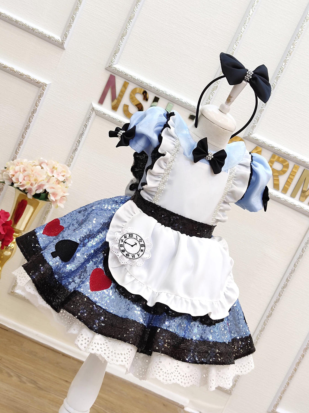 Alice Wonderland inspired baby dress set against a storybook backdrop, perfect for a Disney dress-up photoshoot.