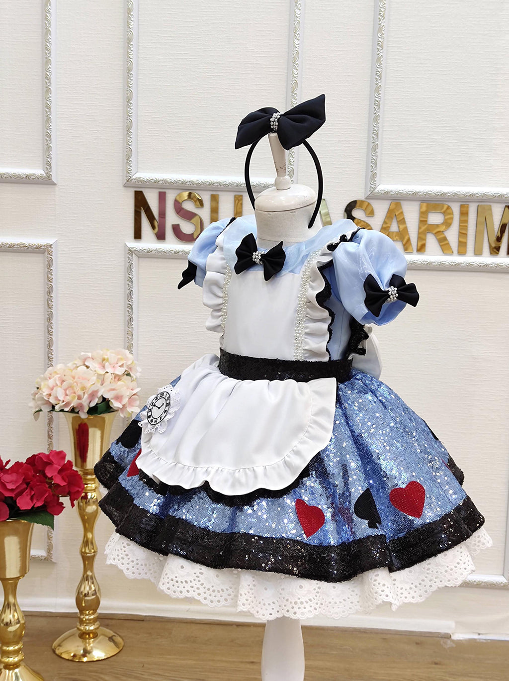 Disney Alice costume. Toddler twirling in a sparkly blue Alice birthday costume dress with a big bow and lace accents.