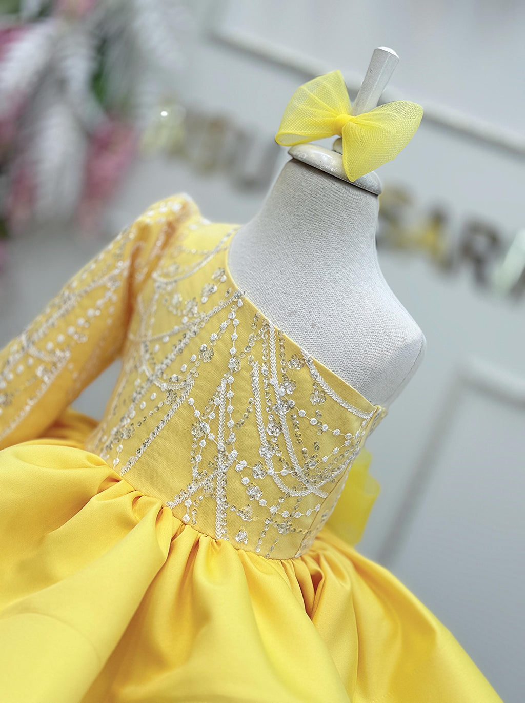 Toddler girl wearing a pink one shoulder fairy princess dress with a full tulle skirt at her first birthday party.