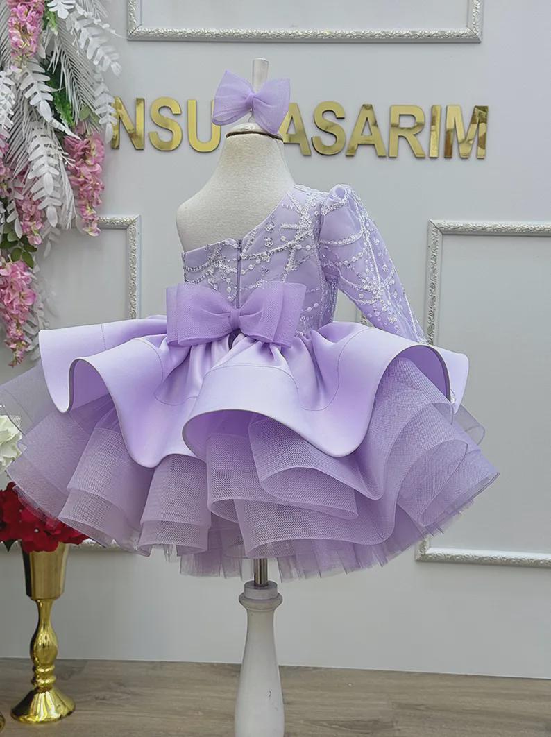Lavender one shoulder baby sundress with a full tulle skirt and cotton lining for a comfortable first birthday outfit.